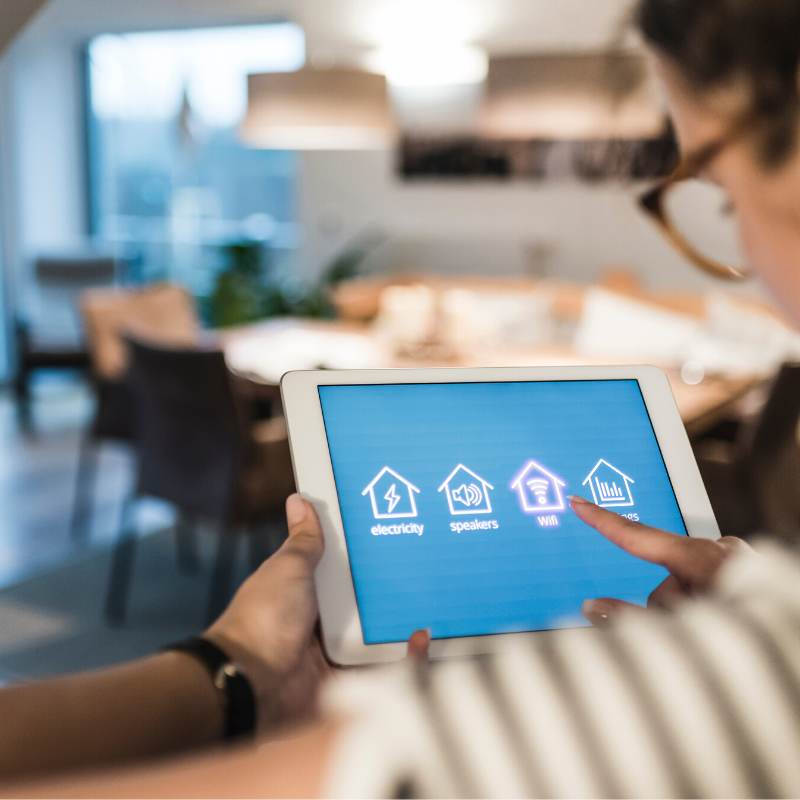 Woman controlling her Wi-Fi from a smart home device in her kitchen